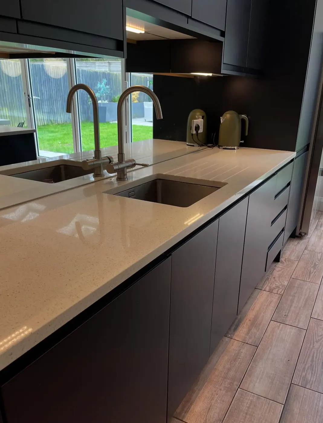 Dark kitchen with quartz worktop and twin undermount sinks